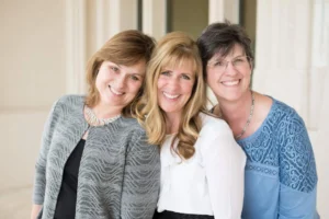 Three team wellness mentors posing and smiling at the camera.